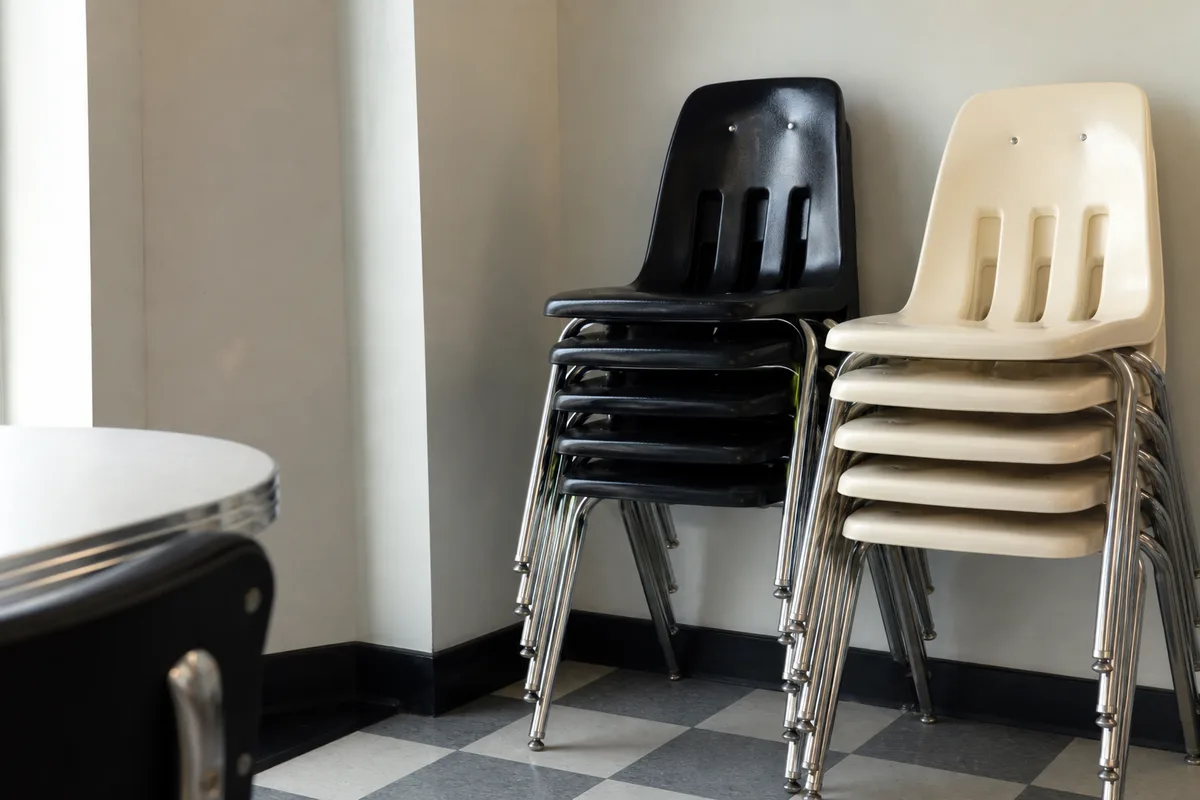 Chaises de style diner américain empilées dans une réserve, structure chromée et assise polypropylène